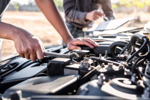 Two mechanics inspecting Hyundai i45 engine in a workshop, highlighting engine accessibility for maintenance and repairs related to engine size.