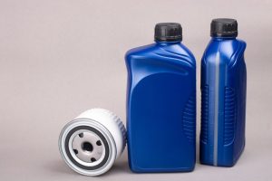 Two blue bottles of engine oil and an oil filter, essential items for performing an engine oil change for a Hyundai i20. The image highlights the importance of using the correct engine oil and filter for optimal vehicle performance.