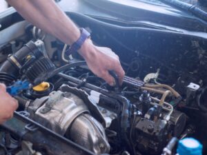 Mechanic working on engine components of a Hyundai.